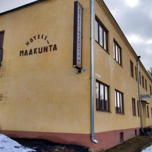 a building with a sign on the side of it at Boutique Hotelli Maakunta in Forssa