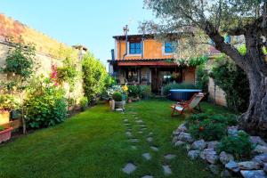 un jardín con un banco y un árbol en el patio en Canalba Casa Rural, en Cembranos