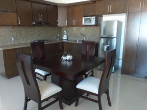 eine Küche mit einem schwarzen Tisch mit Stühlen und einem Kühlschrank in der Unterkunft RENTA VACACIONAL A 2 CUADRAS DE LA PLAYA O MALECON DE MAZATLAN in Mazatlán
