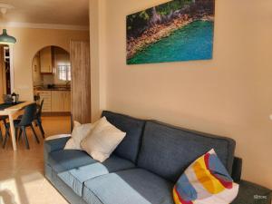 sala de estar con sofá azul y cocina en Apartamento Picasso, en Nerja