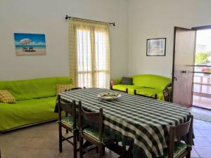 a living room with a table and a green couch at Paradise House in Alcamo Marina