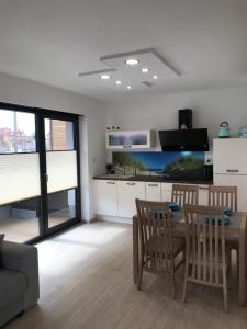 a kitchen and living room with a table and chairs at Apartament FAMILY Gardenia Dziwnów in Dziwnów