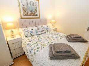 a bedroom with a bed with towels on it at The River Appartment in Todmorden