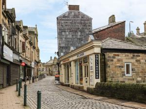 a cobblestone street in a city with buildings at The River Appartment in Todmorden