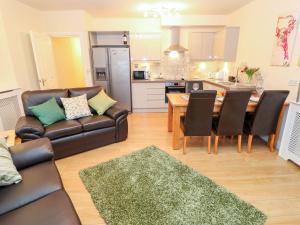 uma sala de estar com um sofá e uma mesa em The River Appartment em Todmorden