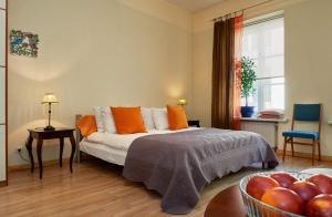 a bedroom with a bed with orange pillows and a bowl of fruit at ReHouse- Zemaitijos 11 in Vilnius