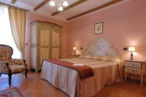 a bedroom with a large bed and a chair at Agriturismo Casa Castellini in Garbagna
