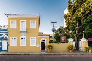 un edificio amarillo con ventanas blancas y una puerta en NovoHotell Recife, en Recife