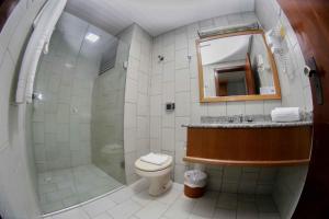 uma casa de banho com um chuveiro, um WC e um lavatório. em Susin Hotel em Mafra