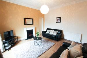 a living room with a couch and a fireplace at Oban Town Centre Apartment in Oban
