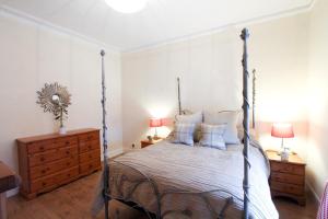 a bedroom with a canopy bed and two night stands at Oban Town Centre Apartment in Oban