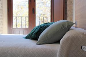 a bed with two pillows on it with a window at Apartamentos Reyes Catolicos 14 in Seville