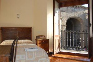 a bedroom with a bed and a balcony at Hostal Paris in Jaca