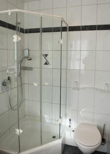 a bathroom with a shower and a toilet and a tub at Hotel und Gasthof Soller in Ismaning
