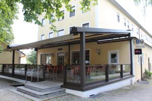 toldo en el lateral de un edificio con mesas y sillas en Hotel und Gasthof Soller, en Ismaning