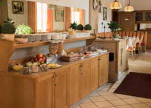 a kitchen with wooden cabinets and fruits on the counter at Hotel und Gasthof Soller in Ismaning