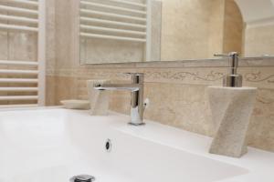bagno con lavandino e 2 rubinetti di L'ANTICA PIETRA Casa Vacanza Salento a Poggiardo