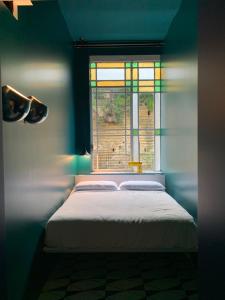 a blue bedroom with a bed and a window at PrimoPianoPosillipo in Naples