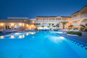 a large swimming pool in a hotel at night at Filoxenia Hotel Zakynthos in Tsilivi