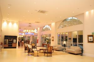 a lobby with chairs and a table in a building at Bourbon Cambará Hotel in Cambará