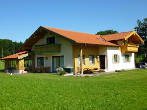 una casa con un césped verde delante de ella en Gästehaus Annemarie en Rimsting