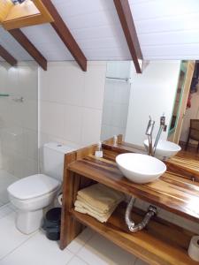 a bathroom with a sink and a toilet at Triplex 3 suítes em Canela in Canela