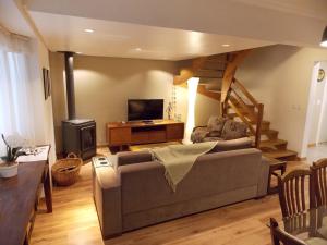 a living room with a couch and a staircase at Triplex 3 suítes em Canela in Canela