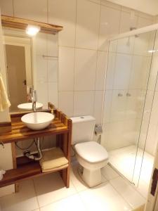 a bathroom with a toilet and a sink and a shower at Triplex 3 suítes em Canela in Canela