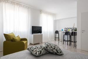 sala de estar con sofá amarillo y TV en Wonderful Italy Suites, en Siracusa