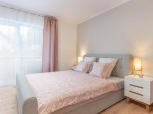 a bedroom with a large bed and a window at Alpe-Adria Apartments Chanel top12 in Oberaichwald