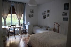 1 dormitorio con 1 cama, mesa y sillas en Les Hauts de Perrache, en Sainte-Foy-lès-Lyon