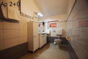 a small bathroom with a toilet and a sink at Apartments Mira in Starigrad