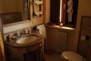 bagno con lavandino in legno e servizi igienici. di La Suite nel Bosco a Selva di Fasano