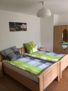 - une chambre dotée d'un lit avec des draps verts et bleus dans l'établissement Ferienwohnung Im Bachgrund, à Schlitz