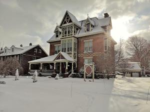 ein großes Haus mit Schnee auf dem Boden in der Unterkunft Spencer House Bed & Breakfast in Erie