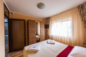a bedroom with a bed with two towels on it at Apartament Carol Davila in Piteşti