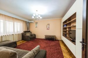 a living room with a couch and a tv at Apartament Carol Davila in Piteşti