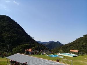una vista de un campo de fútbol con montañas en el fondo en Chalé duplex reformado - Fazenda Cantinho en Teresópolis