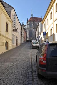 a street with cars parked on a cobblestone street at Pension Pod věží in Kolín