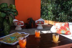a table with two glasses of orange juice on a patio at le Cocon in Le Moule