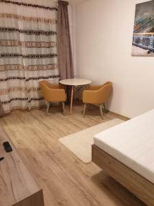 a room with a table and two chairs and a bed at Focus Home in Miercurea-Ciuc
