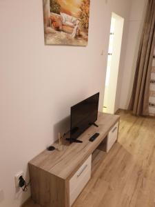 un soggiorno con TV a schermo piatto su un tavolo in legno di Focus Home a Miercurea-Ciuc