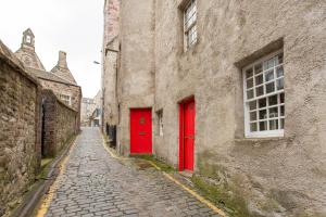 an alley with red doors in an old building at Charming Apartment in the Old Town in Edinburgh