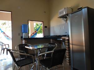 uma cozinha com uma mesa e um frigorífico de aço inoxidável em Chalés Sinfonia do Mar - Vista Paradisíaca em Icapuí