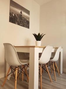 a dining room table with white chairs and a plant at PISO TURÍSTICO MAGA - LUXURY FLOOR IDEAL FAMILIAS in Zamora