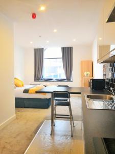 a kitchen with a table and a bed in a room at Horse Fair Apartments in Birmingham City Centre by HF Group in Birmingham