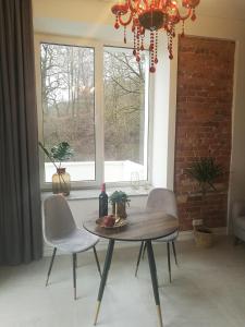 a table and chairs in a room with a window at Apartamentai Veiveriu 16 in Kaunas