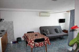 a living room with a table and a couch at Guest house Mediteran Relax in Makarska