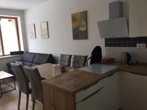 a kitchen and living room with a table and chairs at Apartmán Čihadla in Bedřichov
