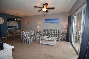 a living room with two chairs and a ceiling fan at 113 Cypress Bend Condo in North Myrtle Beach